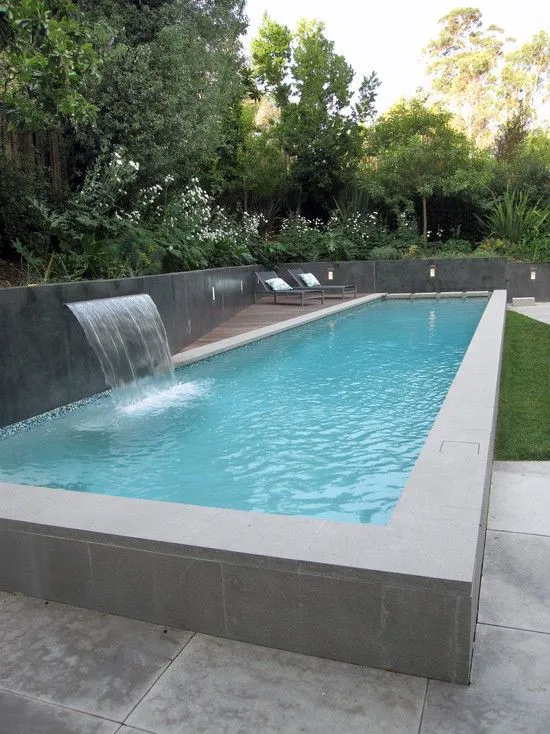 Custom pool with sheet waterfall feature and wood lounge deck