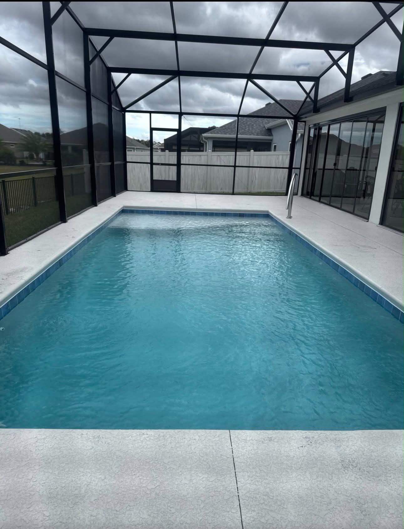 Screened pool enclosure with concrete deck, a common backyard style